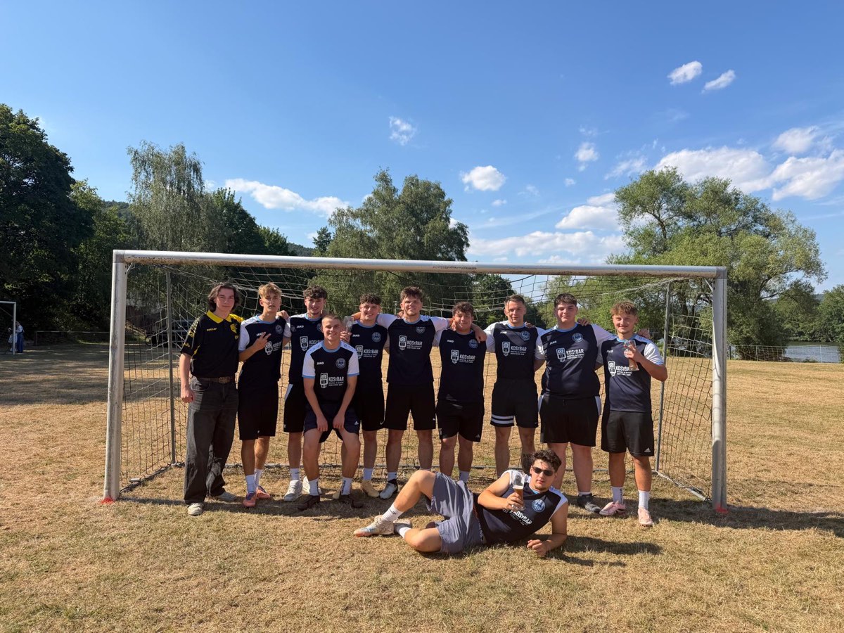 Die Mannschaft von Fox River 8 in dunklen Trikots vor einem Fußballtor auf einer Wiese